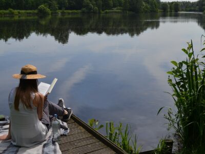 Women studying God's Word on dock by the lake.